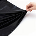 Load image into Gallery viewer, Sheet lifted by hand showing the weight and flexibility of the PVC