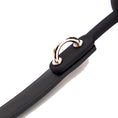 Load image into Gallery viewer, Macro view of a gold D-ring seated in a moulded tab on the smooth black strap