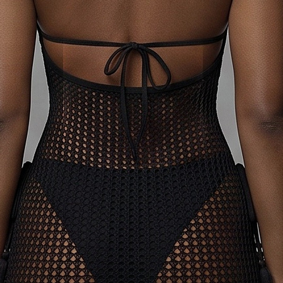 Detail of the black dress's low scoop back edge and mesh across the shoulder blades