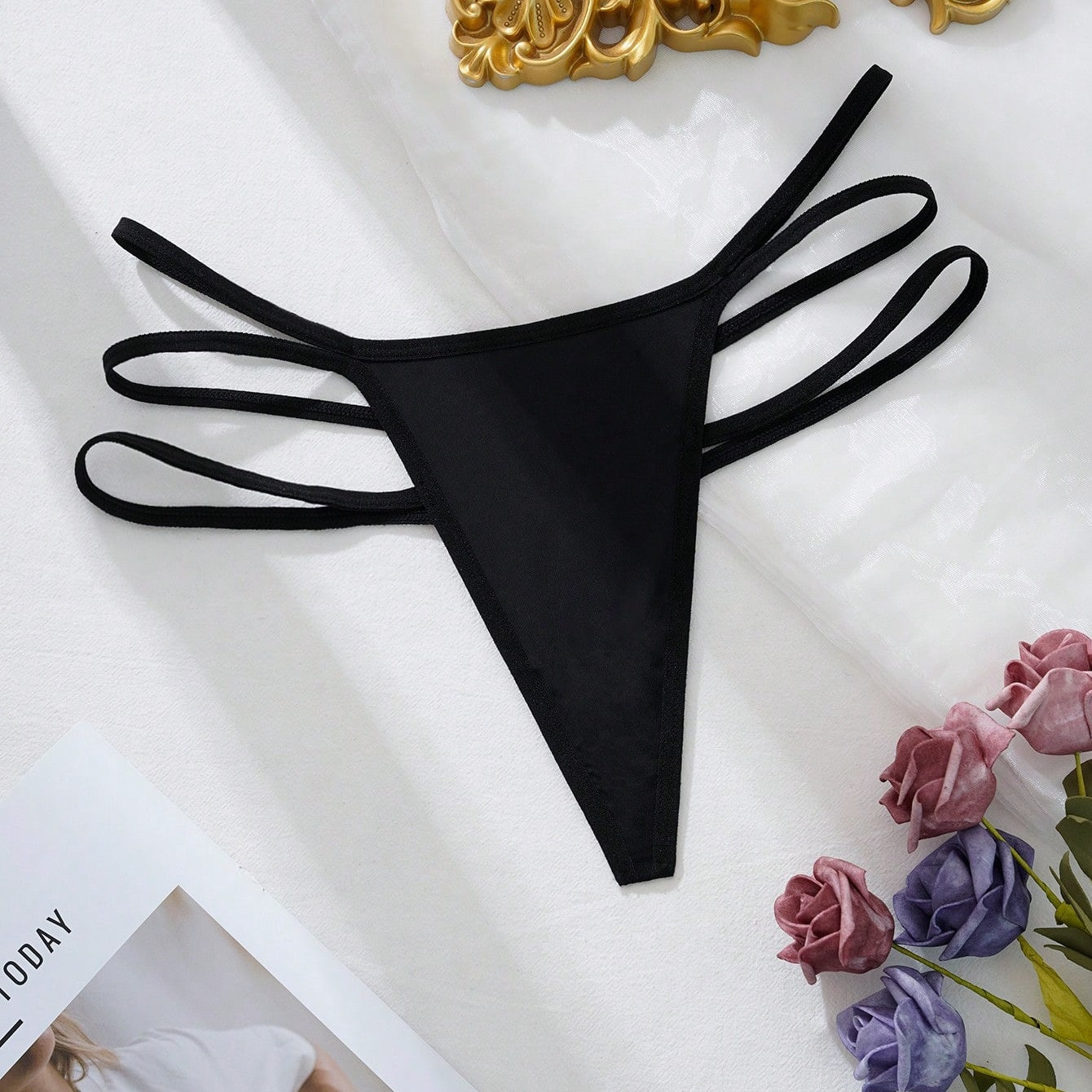 Black triple-strap thong laid flat, full garment