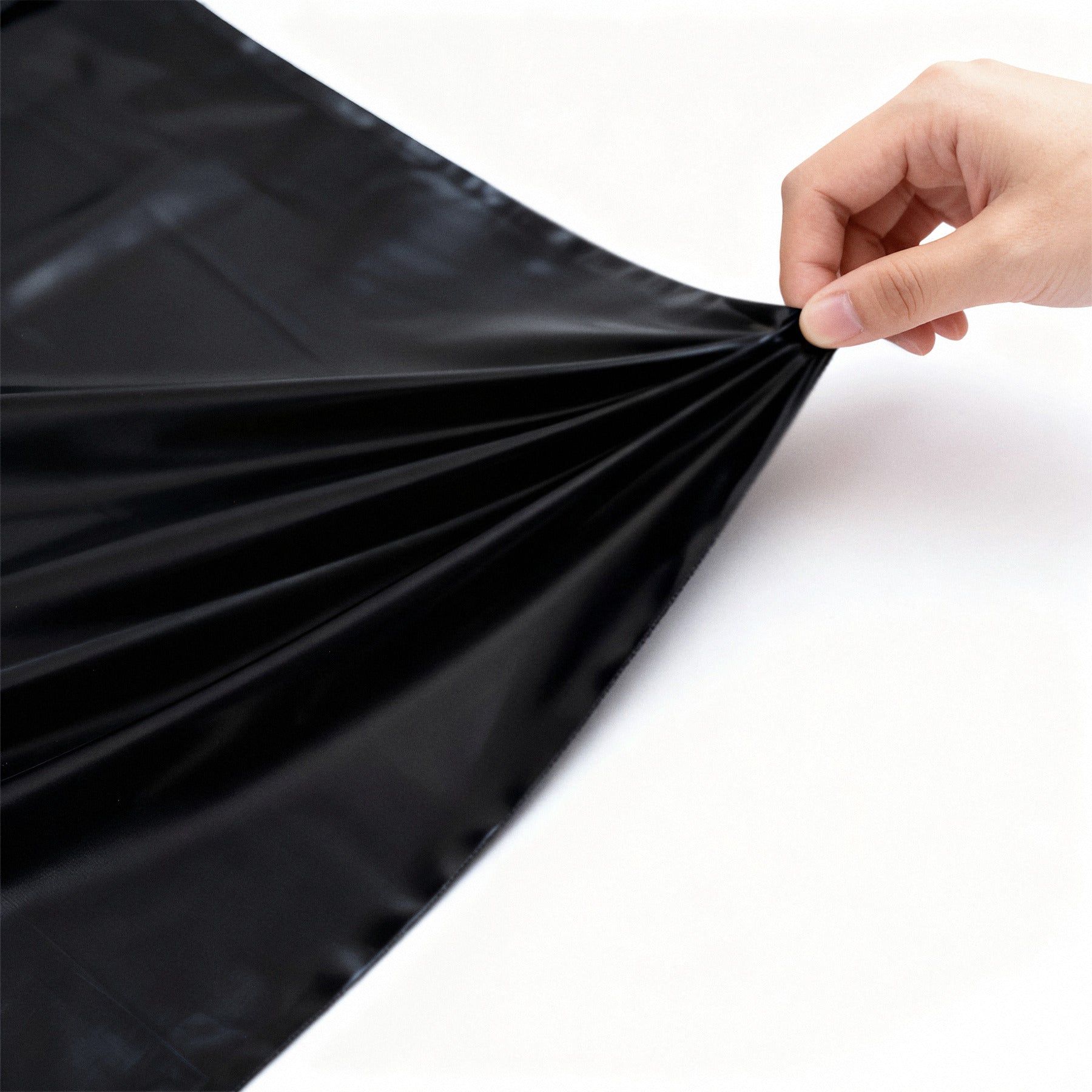Sheet lifted by hand showing the weight and flexibility of the PVC