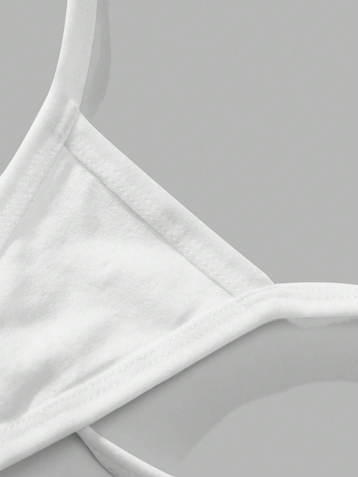 Close-up of the white cotton fabric and stitched strap edge