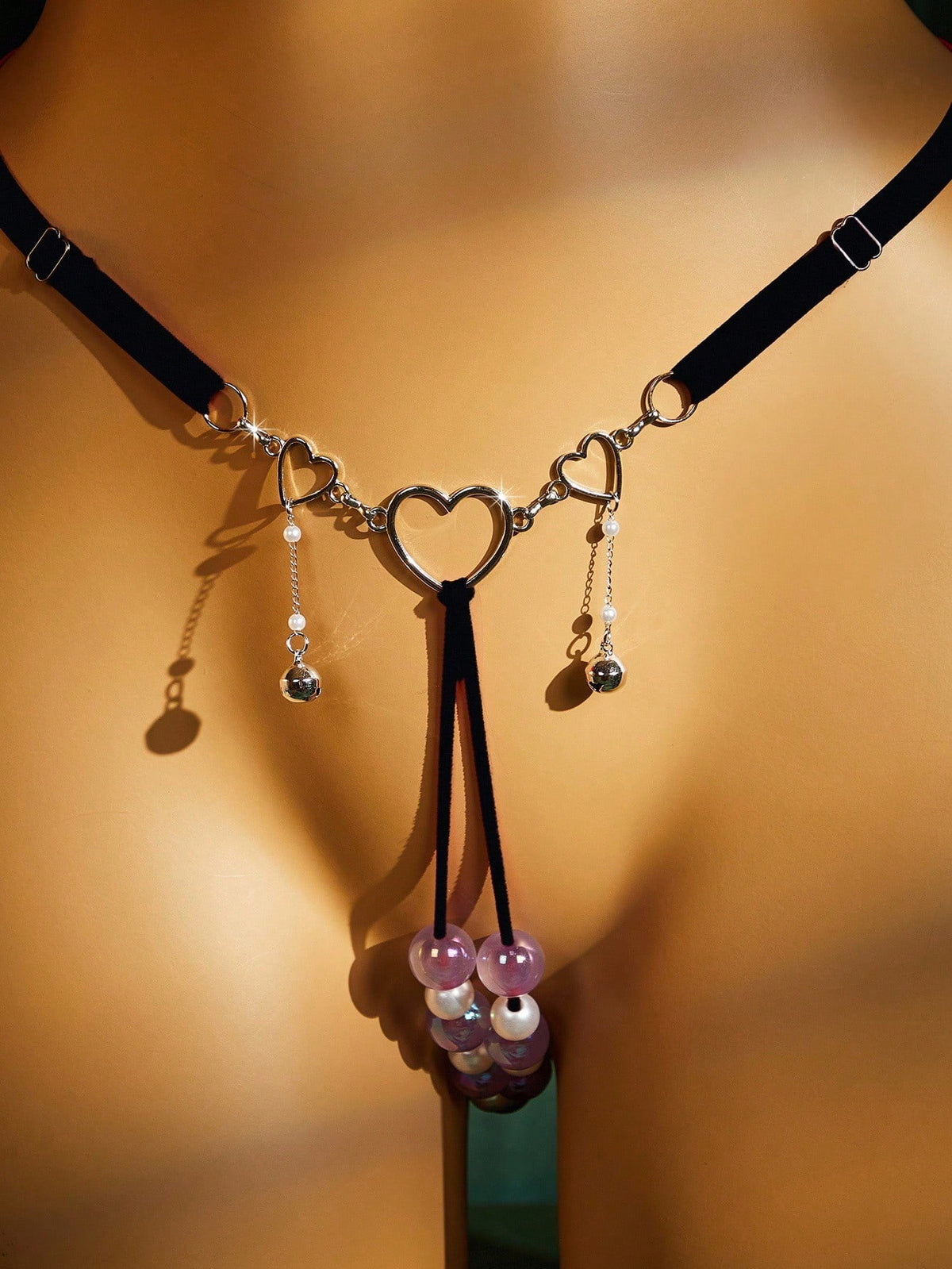 Close-up of the gold heart ring, pearl drop charms and faux pearl strand