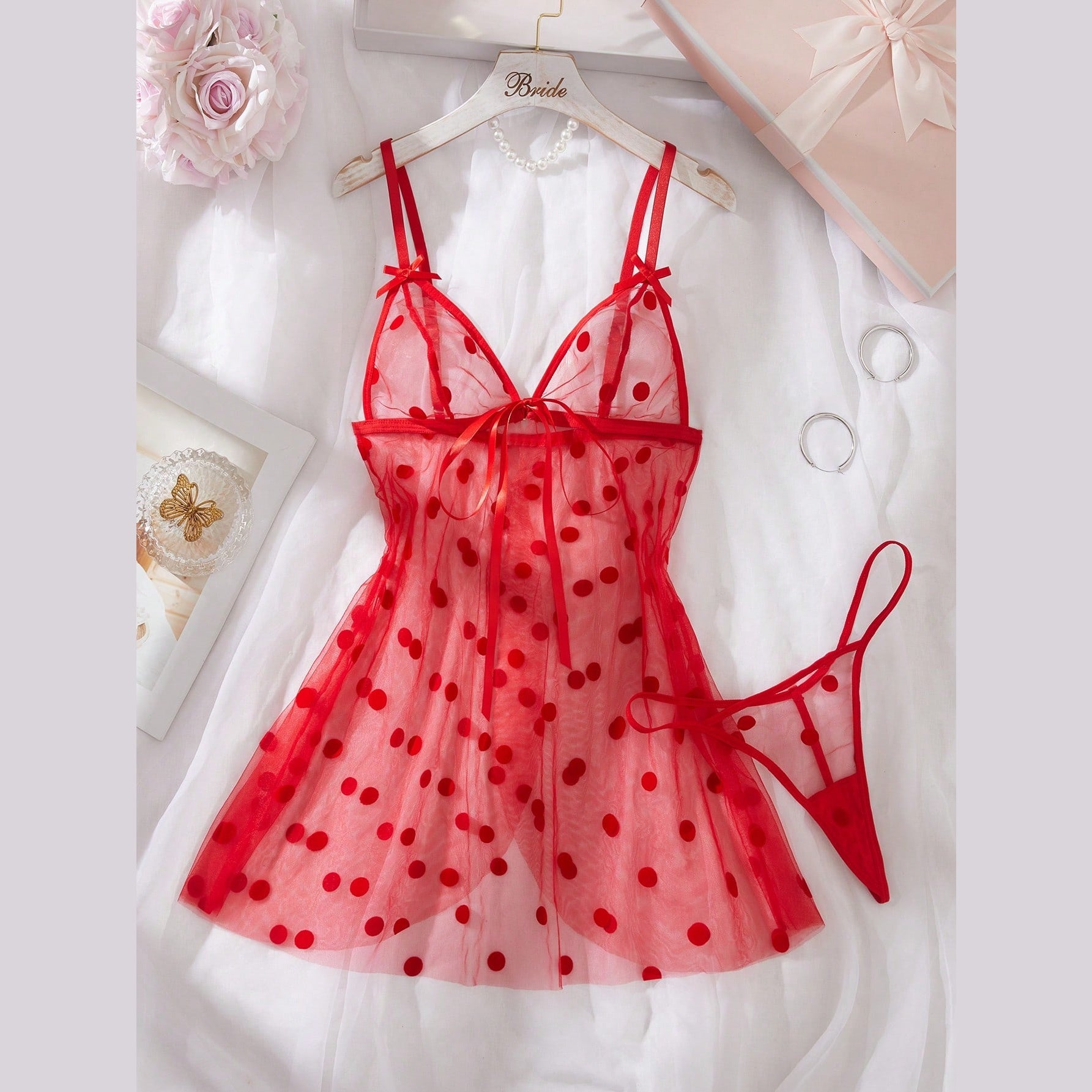 Red polka dot mesh babydoll set laid flat with matching thong