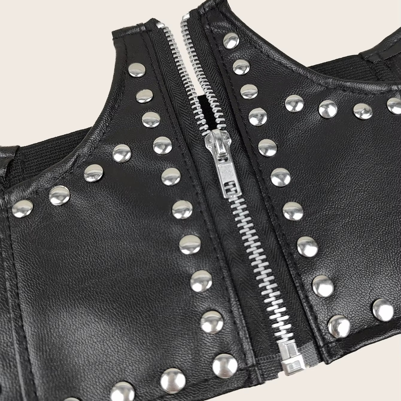 Close up of silver rivets and the full-length front zip