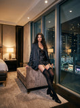 Cargar la imagen en la vista de la galería, Black garter stockings seated indoors with a satin set, showing where the band sits on the thigh
