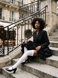Cargar la imagen en la vista de la galería, Seated in white garter stockings with a black blazer, showing a strap leaving the top band on the thigh
